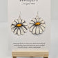 Oopsy Daisy Hand Painted Paper Earrings. Flower shaped heavy weight paper painted to resemble a white daisy with yellow center. Ultra light weight. 1 5/8" in diameter. Back of earring is painted in the same design. Resin coated for durability. Sterling silver ear wires and findings. Hangs 2"