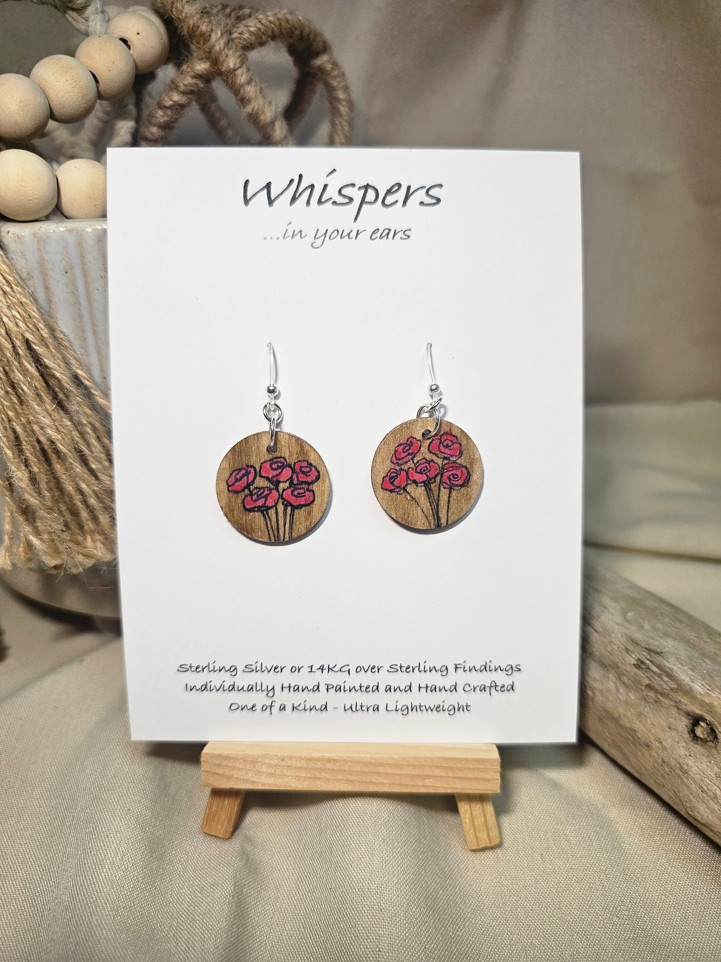 5 Poppies Hand Painted Wood Earrings. Stained 1"wood round, painted with pinkish red bunch of poppies. Ultra light weight. Back of earring is painted in same design. Enameled for durability. Acrylic ear wires, for metal sensitive ear lobes. Hangs 1 1/4"