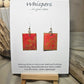 Concentric Gold Hand Painted Paper Earrings. Ultra lightweight 1" x 1 1/4" rectangle painted with Red and orange watercolor . Metallic gold circle design. Back is painted with the same design. Resin coating for durability. Acrylic ear wires. Hangs 1 1/2" in length