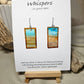 Beach Impressions Hand Painted Paper Earrings. Ultra lightweight 3/4" x 1 1/2" rectangle painted with watercolor. Depicts impressionistic beachscape. Subtle ocean color accents. Edges painted in brown to frame the scene. Back is painted with the same design. Resin coating for durability. Sterling silver ear wires. Hangs 1 3/4" in length
