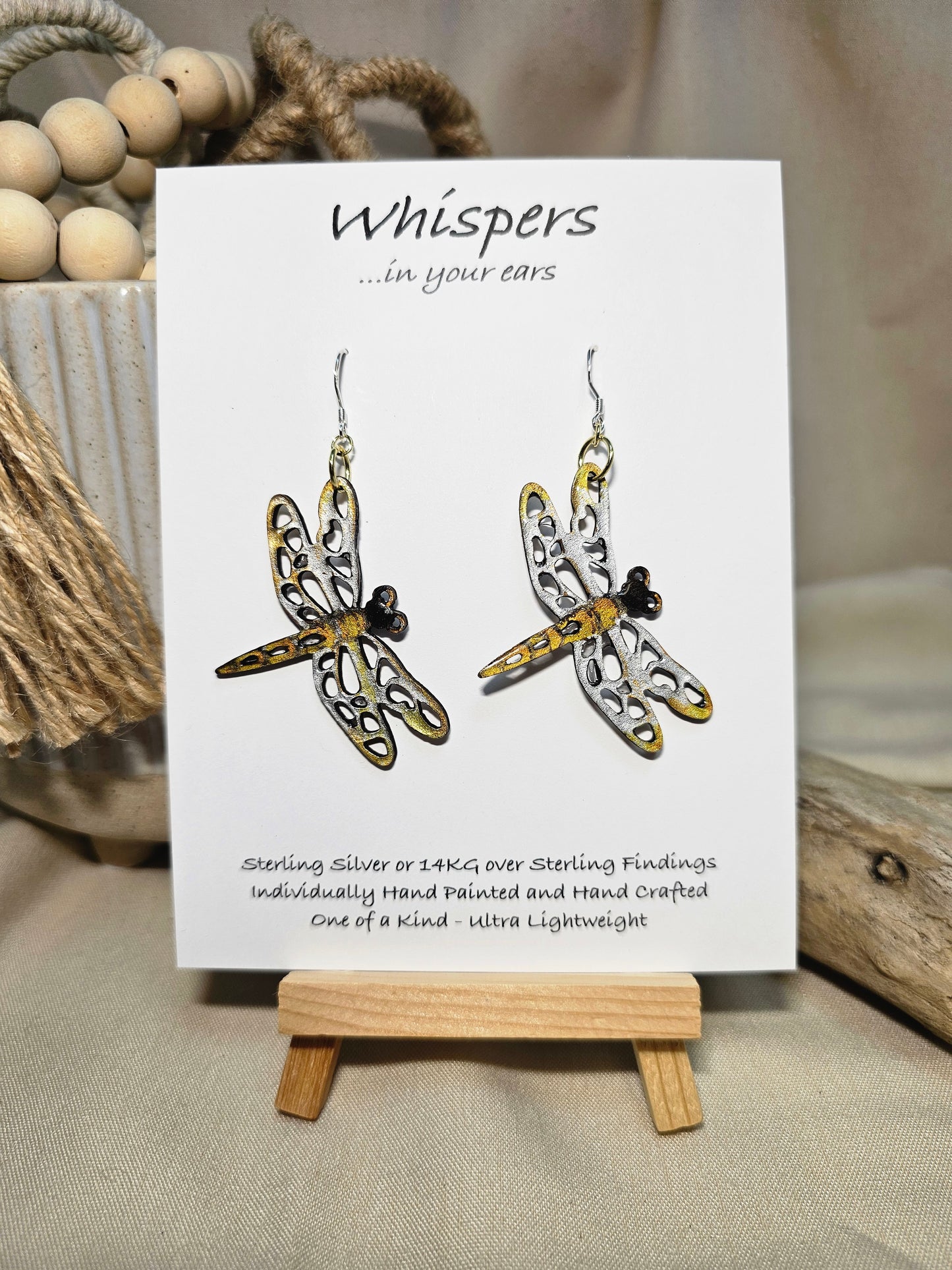 Dragonfly Wood Die Cut Hand Painted in metallic silver, bronze and gold acrylics. Resin coating for durability. Both sides are painted. Ultra light weight. Mixed metal findings of Sterling silver and 14kg over sterling. Hangs 2"