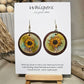 Sunflower Wash Hand Painted Wood Earrings. 1 1/2" wooden round. Hangs inside larger dark stained wood circle pendant. Sunflower painted in watercolor. Yellow, aqua blues, green and brown. Ultra light weight. Back of earring is painted with similar design. Enameled for durability. 14kg over Sterling silver ear wires and findings. Hangs 2"