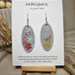 Vertical Floral Collage Bouquet, Hand Painted Wood Earrings. 3D painted flowers and a hand textured aluminum dragonfly. Front and back is painted light grey background. Enameled for durability. 2" Elongated wood oval. 14kg over sterling silver mixed metals with sterling silver findings and hangs 2 1/4" in length