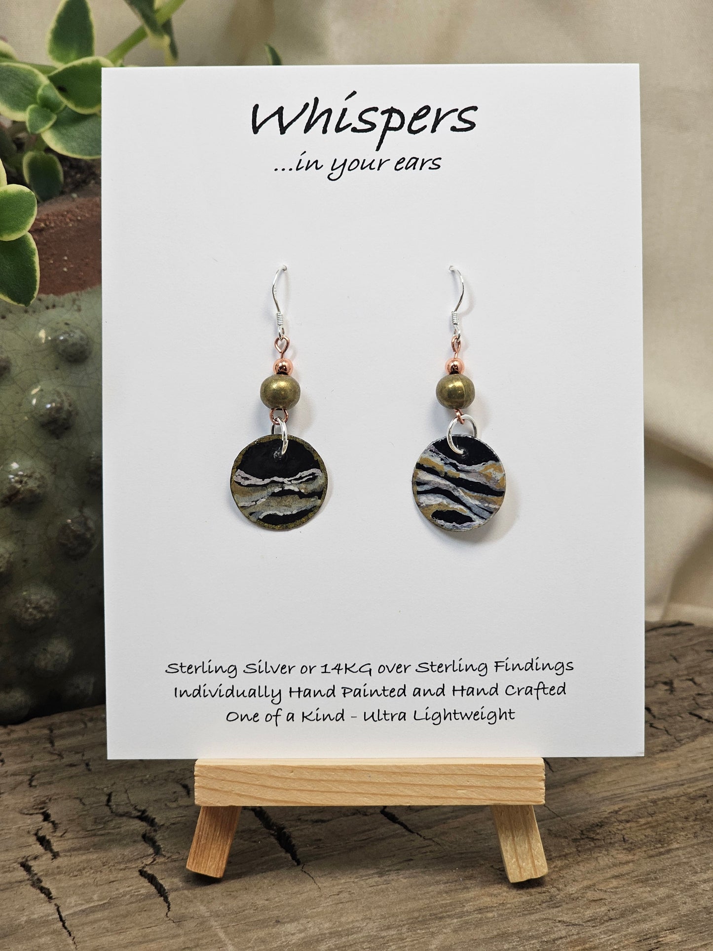 Metallic Wave Hand Painted/Crafted Paper Earrings. 3/4" Circular Drop black artisan paper with metallic painted edges. Hangs from metal decorative gold and olive green beads, Resin Coating for durability. Back is done to compliment. Sterling silver findings. Hangs 1 1/2"