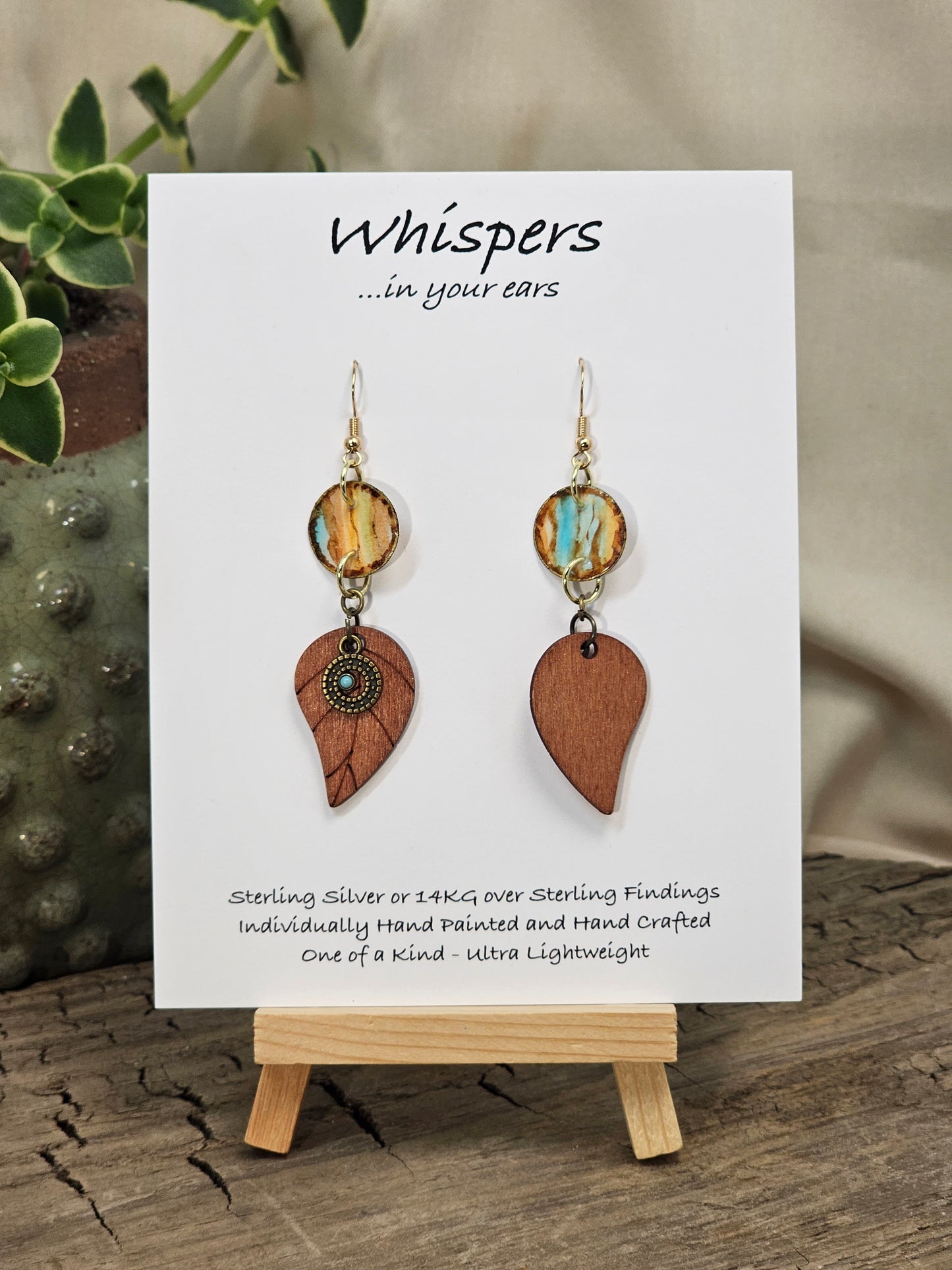 Rustic Leaf Hand Painted Paper Earrings with Wood leaf Pendant. 1/2" Circular artisan paper aqua blue, peach and light brown organic linear pattern with brown painted edges. Resin Coating for durability. Back is done to compliment. 14kg over Sterling silver findings. Hangs 2 1/4"