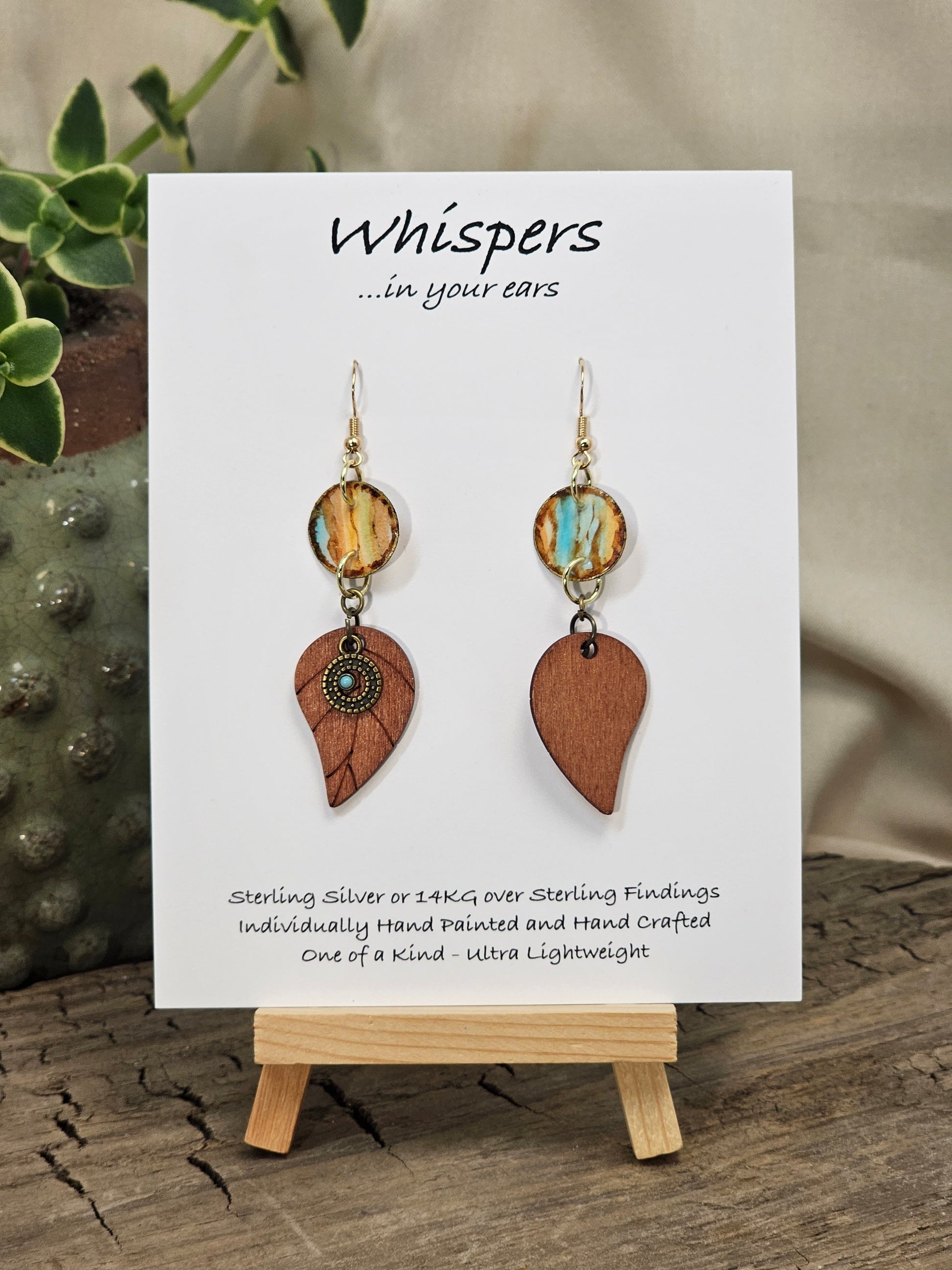 Rustic Leaf Hand Painted Paper Earrings with Wood leaf Pendant. 1/2" Circular artisan paper aqua blue, peach and light brown organic linear pattern with brown painted edges. Resin Coating for durability. Back is done to compliment. 14kg over Sterling silver findings. Hangs 2 1/4"