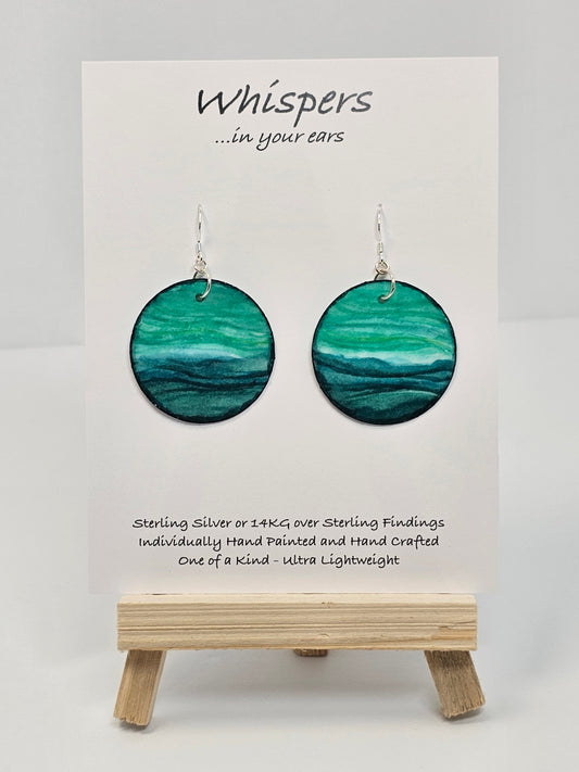 Aqua Blue and teal hand painted paper earrings. Done in watercolor. Impressionistic ocean scape. Circular in shape. Back of earring is painted to match. Ultra lightweight. Resin coated for durability. 1 1/2 in diameter. Sterling findings. Hangs 1 3/4" in length