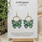 Aqua and Lime Butterfly Hand Painted Wood Earrings. 1"x 1 1/2" Die cut butterfly painted in greens and blues with gold edge accents. Back of butterfly painted in similar design. Hangs gently from gold alloy oval. Hangs 1 5/8". Enameled for durability. 14kg over sterling silver ear wires and findings. Ultra light weight