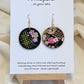 Cherry Blossom Grid Hand Painted/Crafted Wood Earrings. 1 1/2" Wood Disc with handmade paper with painted cherry blossoms painted gold edges. Resin Coating for durability. Back is done to compliment. 14kg over sterling ear wire sterling silver findings. Hangs 1 3/4"