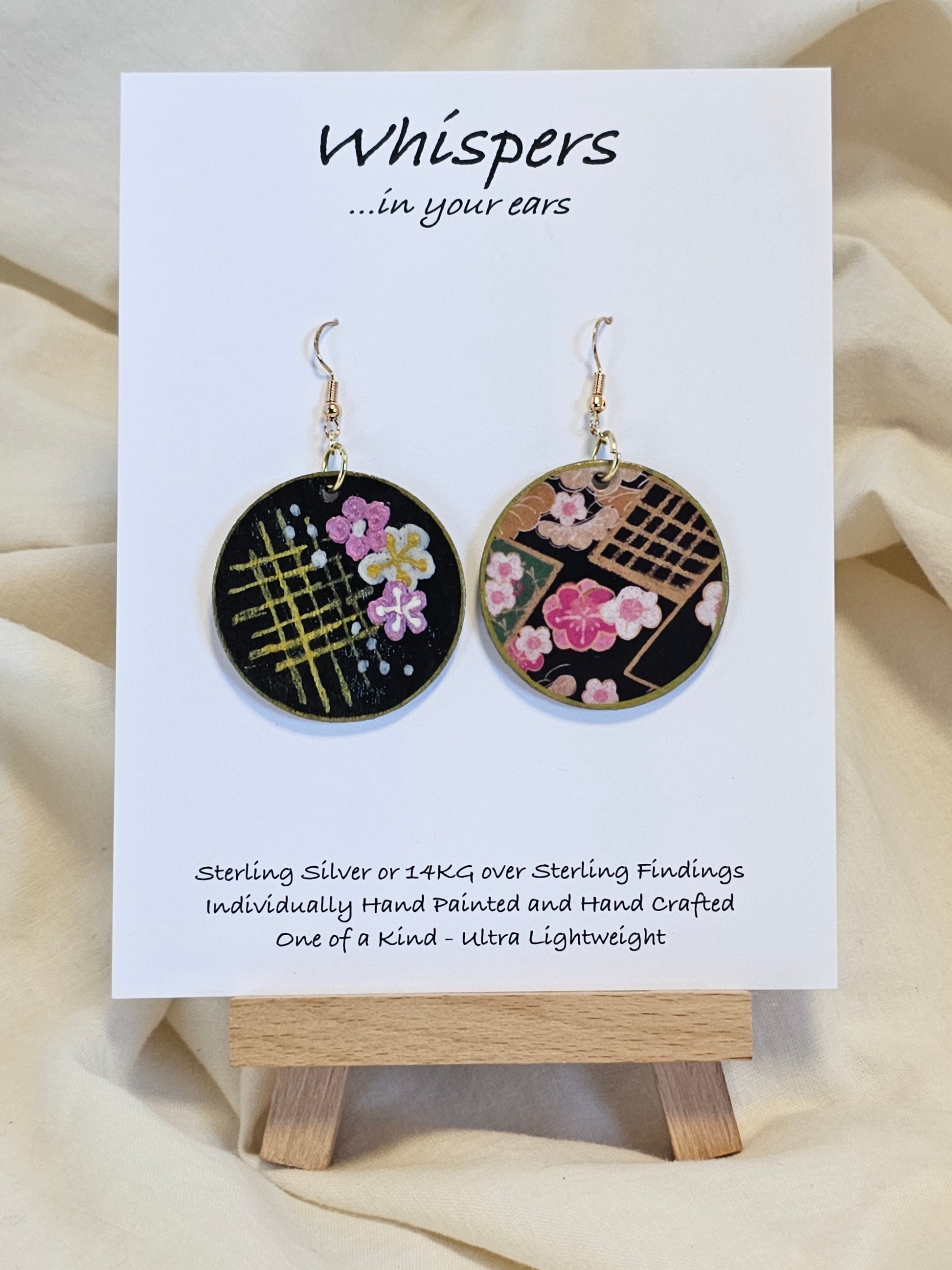 Cherry Blossom Grid Hand Painted/Crafted Wood Earrings. 1 1/2" Wood Disc with handmade paper with painted cherry blossoms painted gold edges. Resin Coating for durability. Back is done to compliment. 14kg over sterling ear wire sterling silver findings. Hangs 1 3/4"