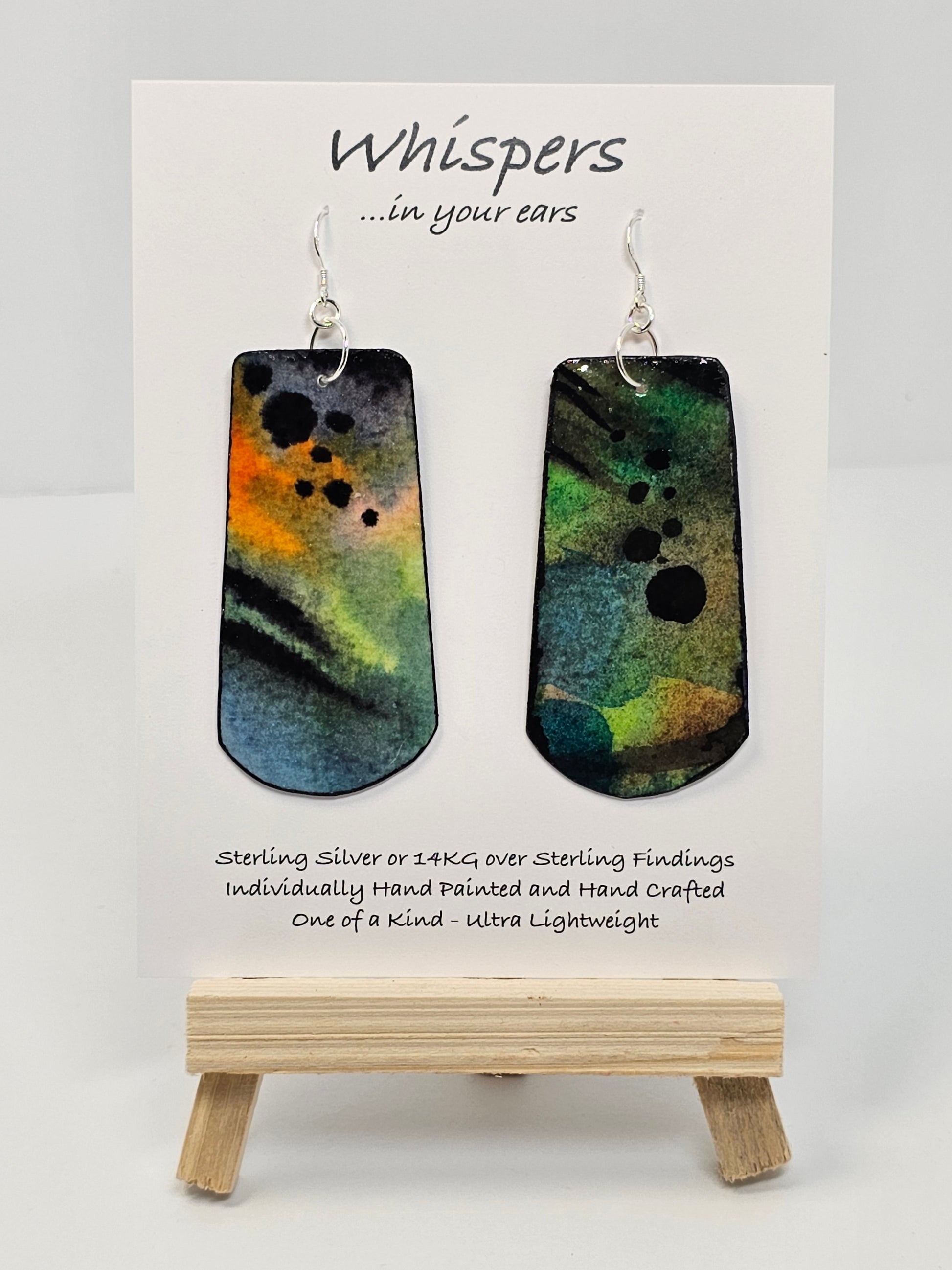 Colorful Fluid Wash Hand Painted Statement Paper Earrings. Large 2 3/4" elongated rectangle with rounded edge. Blues, oranges and black in color. Back is painted in similar design. Edged in black. Resin coated for durability. Ultra light weight. Sterling silver ear wires and findings. Hangs 3"