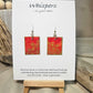 Concentric Gold Hand Painted Paper Earrings. Ultra lightweight 1" x 1 1/4" rectangle painted with Red and orange watercolor . Metallic gold circle design. Back is painted with the same design. Resin coating for durability. Acrylic ear wires. Hangs 1 1/2" in length