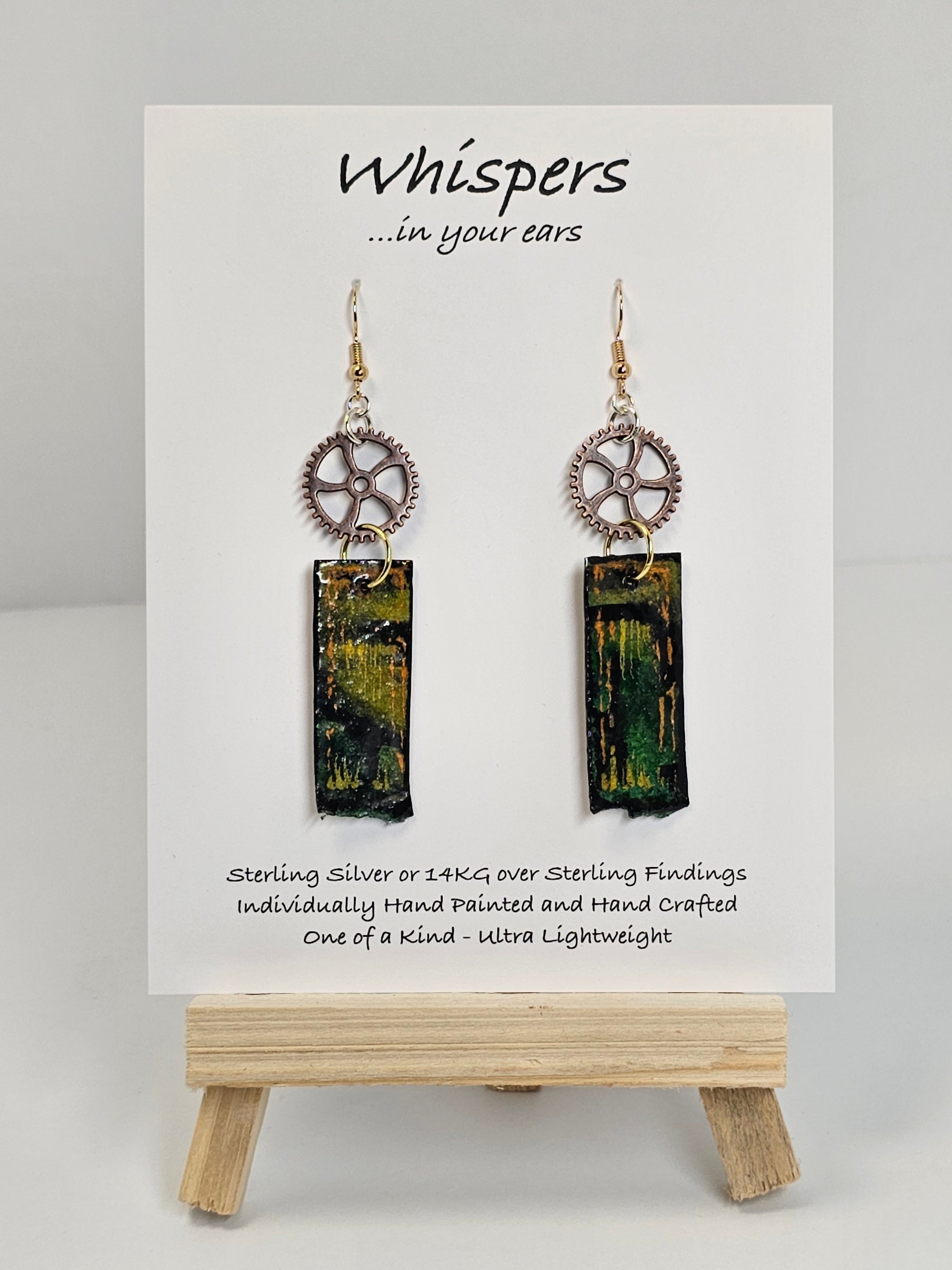 Copper Steampunk Hand Painted Paper and Wood Earrings. 1/2" x 1 5/8" Paper Rectangle hand painted brightly colored background with silver and copper accents. Edged in black. Hanging from Copper notched circular gear.  Back is painted to match. Resin coating for durability. Sterling Silver findings. Hangs 2 1/2" in length