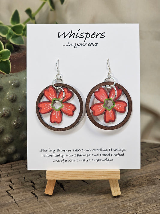 Hawaiian Plumeria Hand Painted/Crafted Earrings. These gorgeous one of a kind Statement earrings are hand painted wooden flower die cut in coral. green and white and have the same design on both sides. Sterling Silver Ear wires and large findings. Large dark stained wood circle encompasses the piece. Enameled for durability. Hangs 2" Ultra light weight
