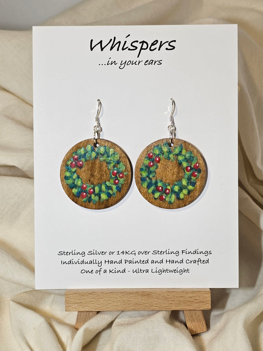 Holly Wreath Hand Painted Wood Earrings. 1 1/2" Stained wood round, two toned Holiday wreath painted with red berries. Back of earring is stained. Enameled for durability. Sterling Silver findings. Hangs 1 3/4"