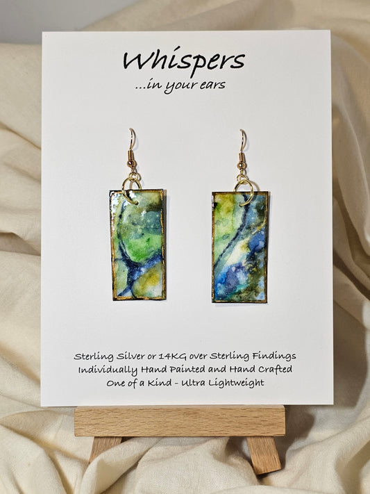Land and Sea Abstract Hand Painted Paper Earrings. 3/4" x 1 1/2" Rectangle painted in watercolor on paper. Resin coated for durability. Mossy green, light green and blues. Edged in gold. Back is painted in similar design. 14kg over sterling silver ear wires and findings. Hangs 1 3/4"