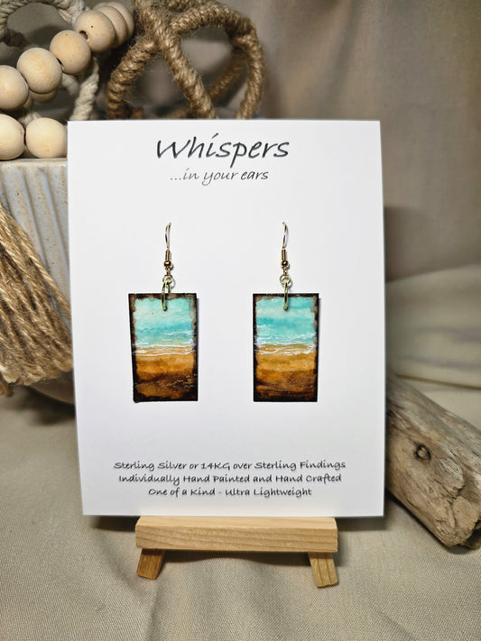 Metallic Beach Hand Painted Paper Earrings. Ultra lightweight 3/4" x 1 1/2" rectangle painted with watercolor. Depicts impressionistic beachscape. Metallic accents in sand. Edges painted in dark brown to frame the scene. Back is painted with the same design. Resin coating for durability. 14kg over sterling silver ear wires. Mixed metals. Hangs 1 3/4" in length