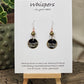 Metallic Wave Hand Painted/Crafted Paper Earrings. 3/4" Circular Drop black artisan paper with metallic painted edges. Hangs from metal decorative gold and olive green beads, Resin Coating for durability. Back is done to compliment. Sterling silver findings. Hangs 1 1/2"
