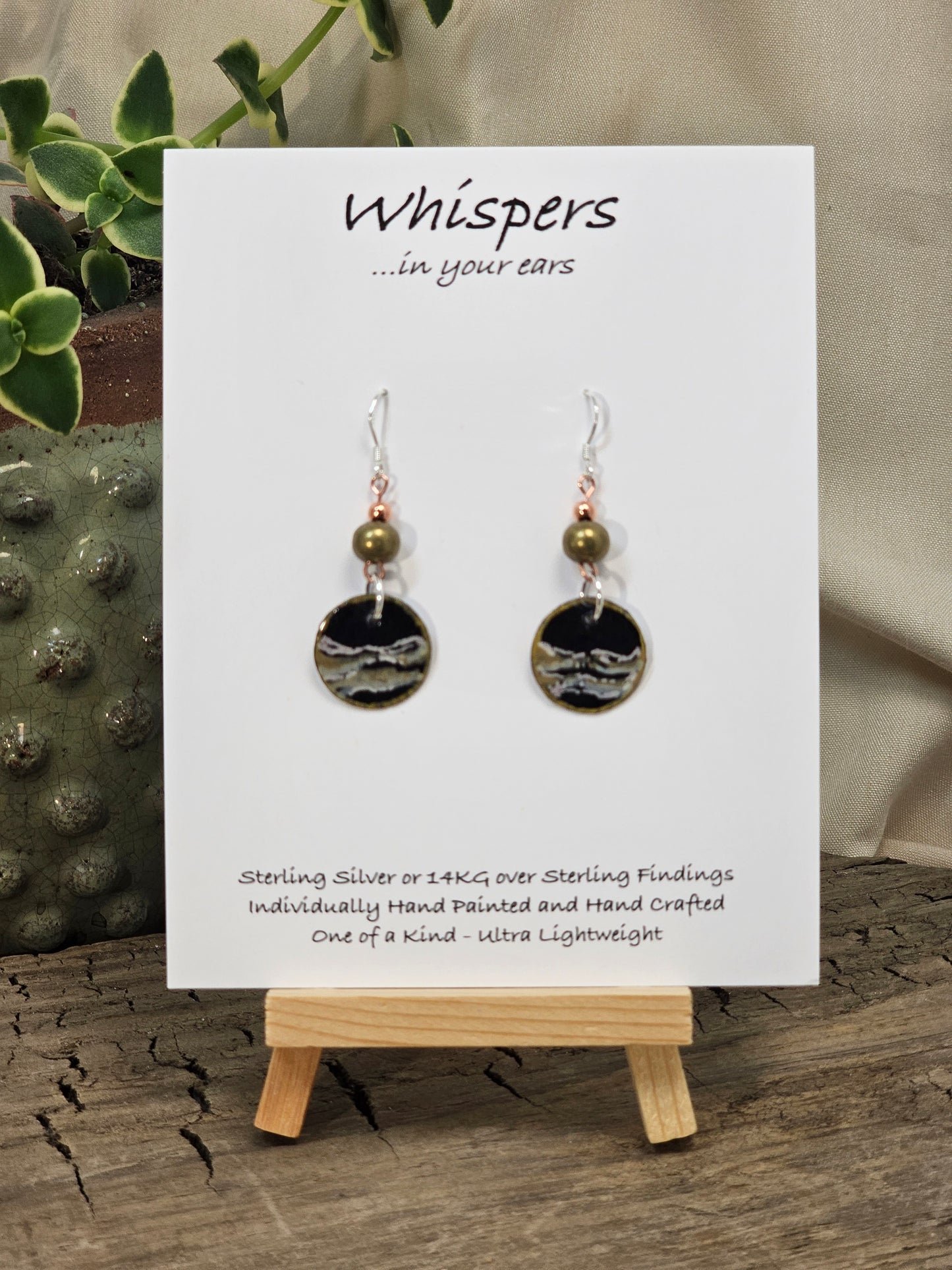 Metallic Wave Hand Painted/Crafted Paper Earrings. 3/4" Circular Drop black artisan paper with metallic painted edges. Hangs from metal decorative gold and olive green beads, Resin Coating for durability. Back is done to compliment. Sterling silver findings. Hangs 1 1/2"