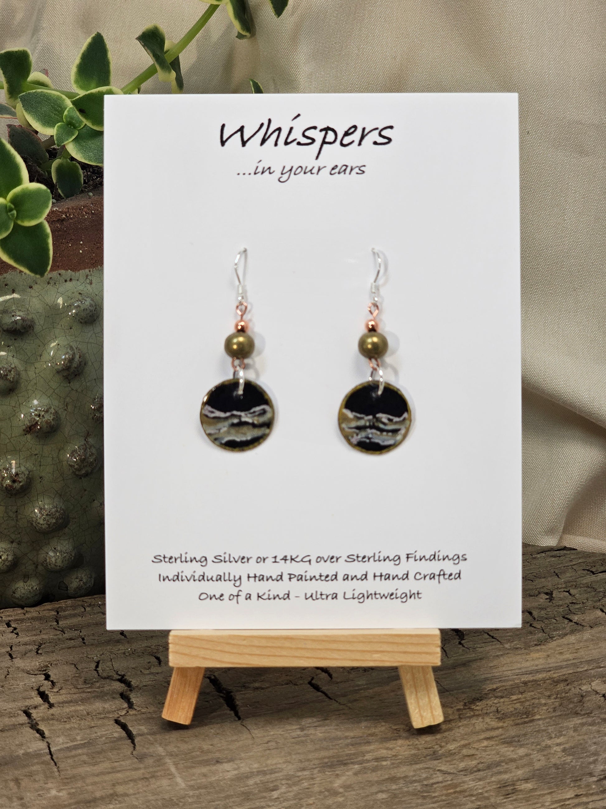 Metallic Wave Hand Painted/Crafted Paper Earrings. 3/4" Circular Drop black artisan paper with metallic painted edges. Hangs from metal decorative gold and olive green beads, Resin Coating for durability. Back is done to compliment. Sterling silver findings. Hangs 1 1/2"