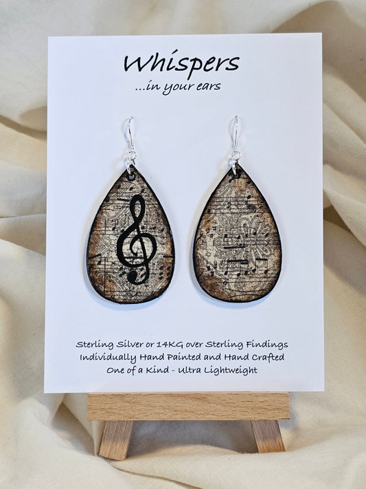 Music Notes Hand Painted/Crafted Wood Earrings. 2" Wood Tear Drop with handmade paper with painted treble cleft painted Black edges. Resin Coating for durability. Back is done to compliment. Sterling silver findings. Hangs 2 1/4"