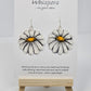 Oopsy Daisy Hand Painted Paper Earrings. Flower shaped heavy weight paper painted to resemble a white daisy with yellow center. Ultra light weight. 1 5/8" in diameter. Back of earring is painted in the same design. Resin coated for durability. Sterling silver ear wires and findings. Hangs 2"
