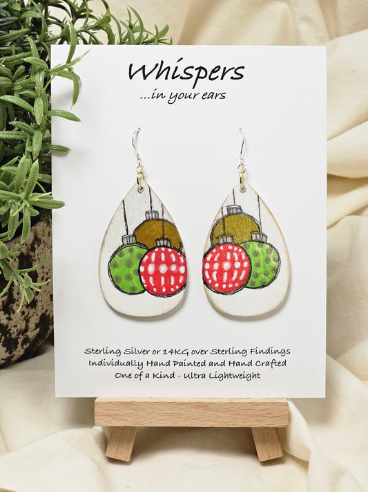 Ornament Trio Hand Painted Wood Earrings. 2" Wood Tear Drop painted white background. Three hand painted. Pattern Ornaments painted red, green and copper, outlined in black. Back is painted white. Distressed edge. Enameled for durability. Sterling Silver ear wires and findings. Ultra light weight. Hangs 2 1/2"