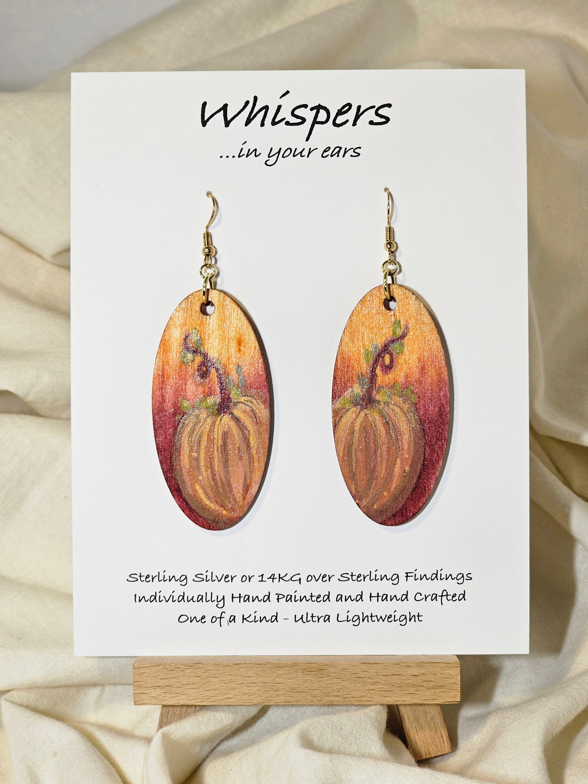 Pumpkin Glow Hand Painted Wood Earrings. Ombre background orange and red. Back painted in similar colors. Enameled for durability. 2" Elongated wood oval. 14kg over sterling silver findings and hangs 2 1/4"