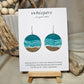 Shore Break Hand Painted Wood Earrings. 1 1/2" wooden round, Beach shoreline landscape painted with acrylics in aqua blues, teal and white. Ultra light weight. Back of earring is painted with similar design. Enameled for durability. Sterling silver ear wires and findings. Hangs 1 3/4"