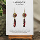 Tiger Striped Feather Hand Painted Paper Earrings. 5/8" circular hand painted paper earring. Below hangs a gorgeous light weight metal enameled feather charm pendant. Back is gold in color. Red brown, gold, black and white, metallic accents edged in gold. Back of paper is painted in similar design and colors. Resin coated for durability. 14kg over sterling silver ear wires and findings. Hangs 2 1/2" in length