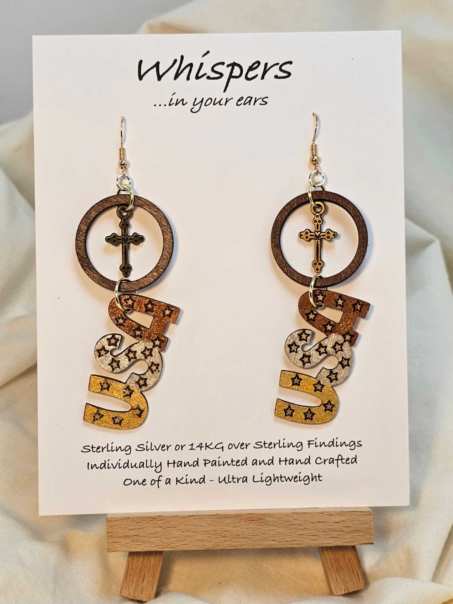 Wooden disc with brass cross, Wood USA Laser cut shape hand painted metallic accents. Hanging from embellished wooden disc painted black. Back is painted to match. Resin coating for durability. Sterling Silver findings. Hangs 2 1/2" in length