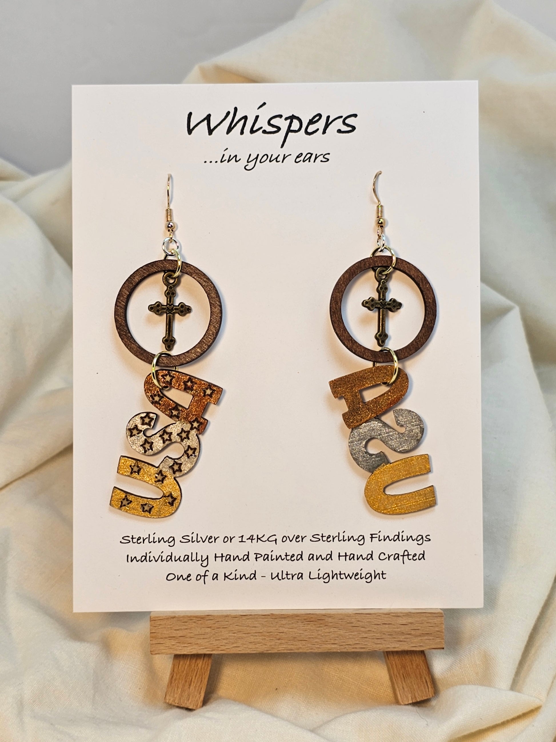 Wooden disc with brass cross, Wood USA Laser cut shape hand painted metallic accents. Hanging from embellished wooden disc painted black. Back is painted to match. Resin coating for durability. Sterling Silver findings. Hangs 2 1/2" in length