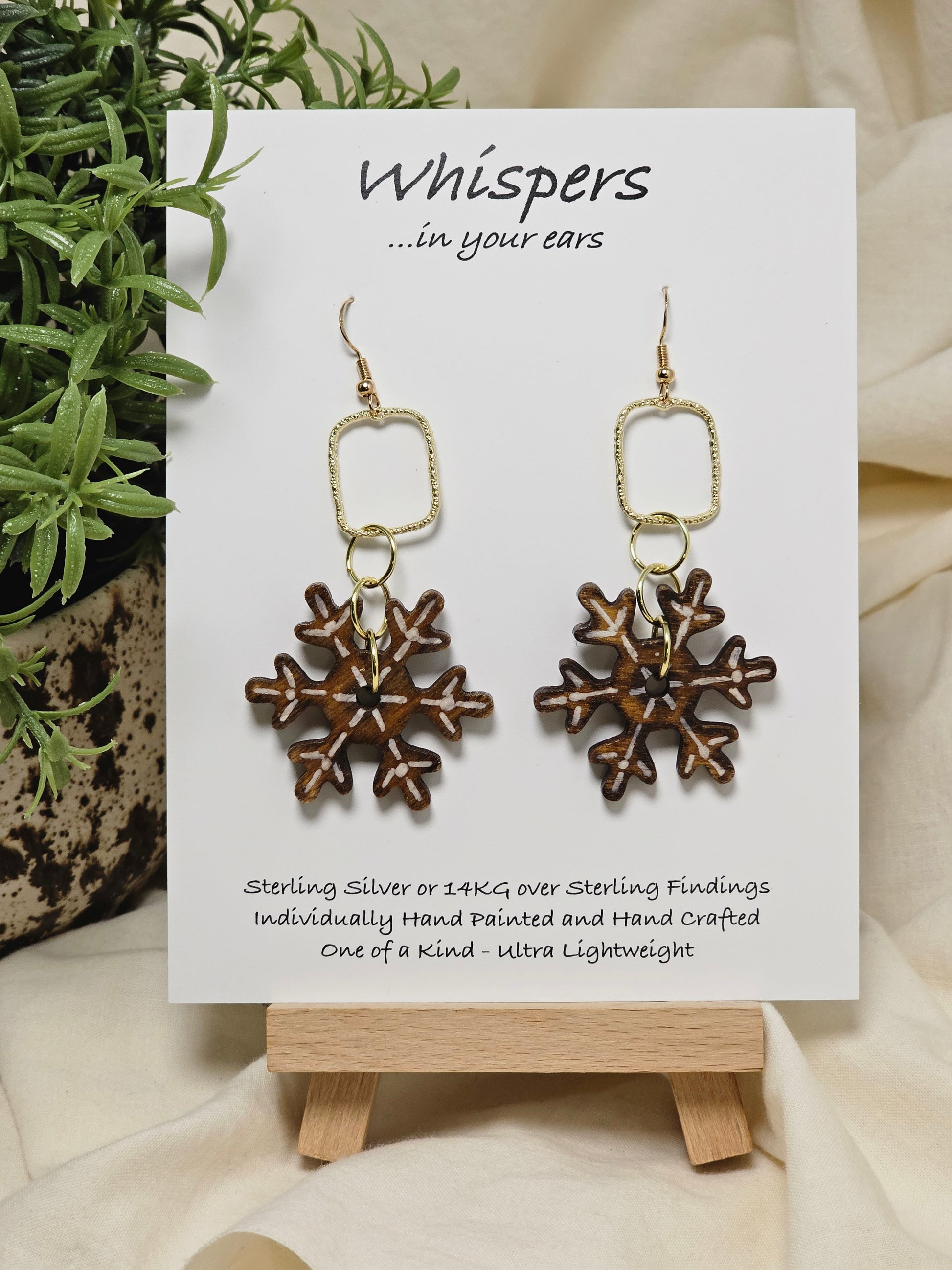Vintage Snowflake Wood and Alloy Earrings. Ultra light weight. 1 1/2" Wood snowflake hand painted and distressed. Hangs from gold alloy square. 14kg ear wires and findings. Back of earring is painted in similar design. Enameled for durability. Hangs 2 1/2" in length