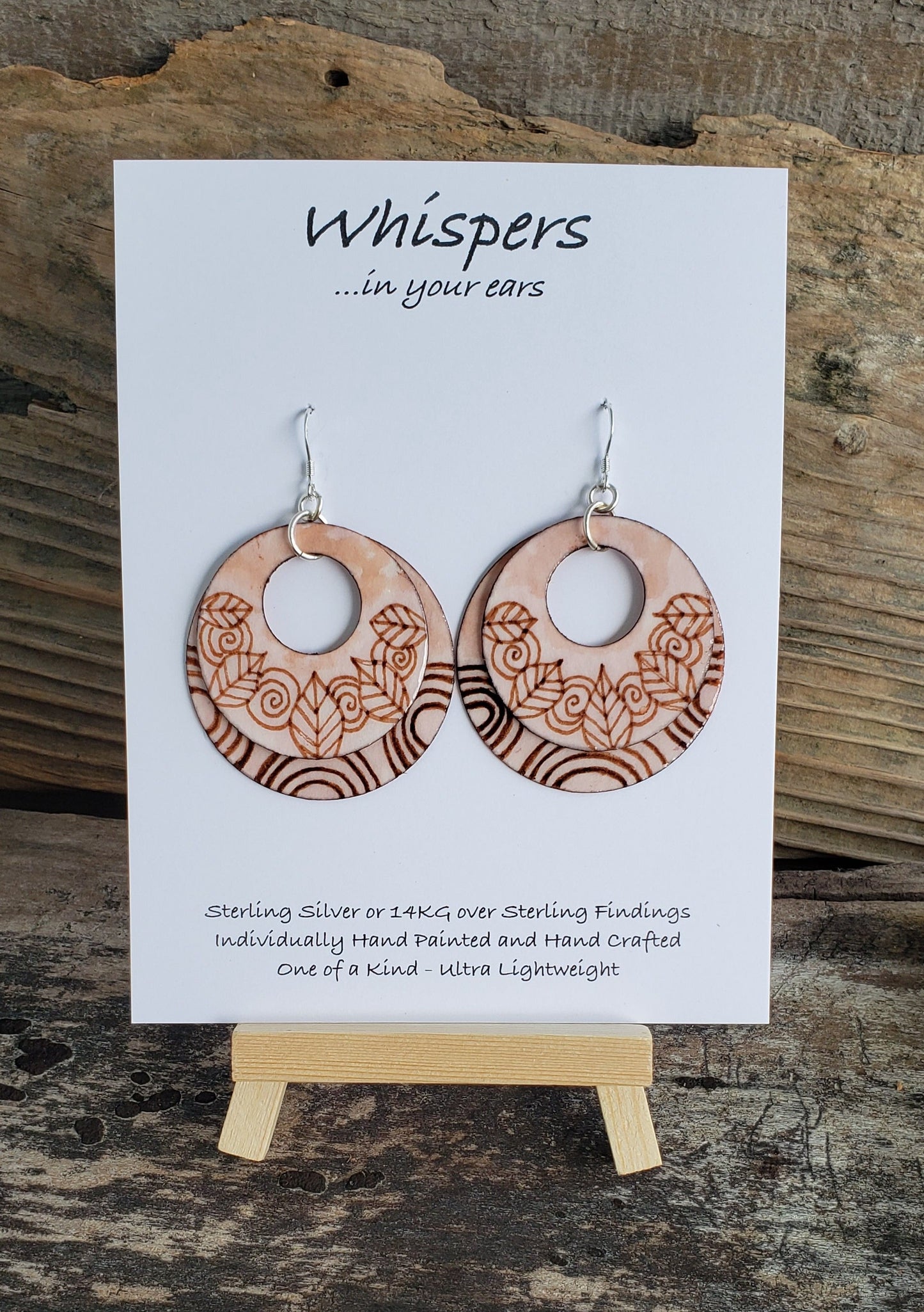 Hand painted watercolor ultra lightweight paper earrings. Feathers and swirls faux wood burned look. Double Layer. Solid painted back. Circular in shape. Sterling silver findings. Hangs 2" in Length