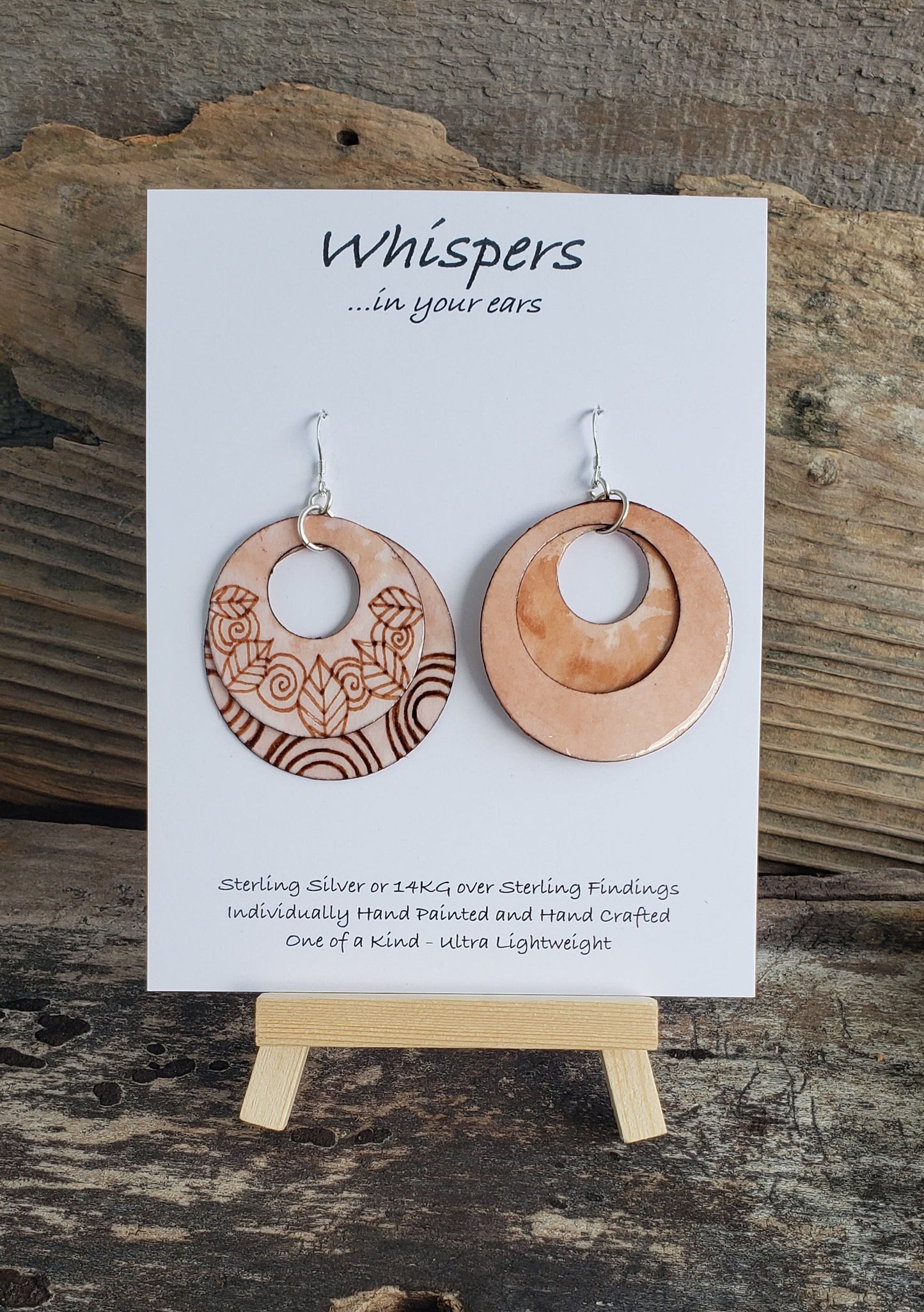 Hand painted watercolor ultra lightweight paper earrings. Feathers and swirls faux wood burned look. Double Layer. Solid painted back. Circular in shape. Sterling silver findings. Hangs 2" in Length