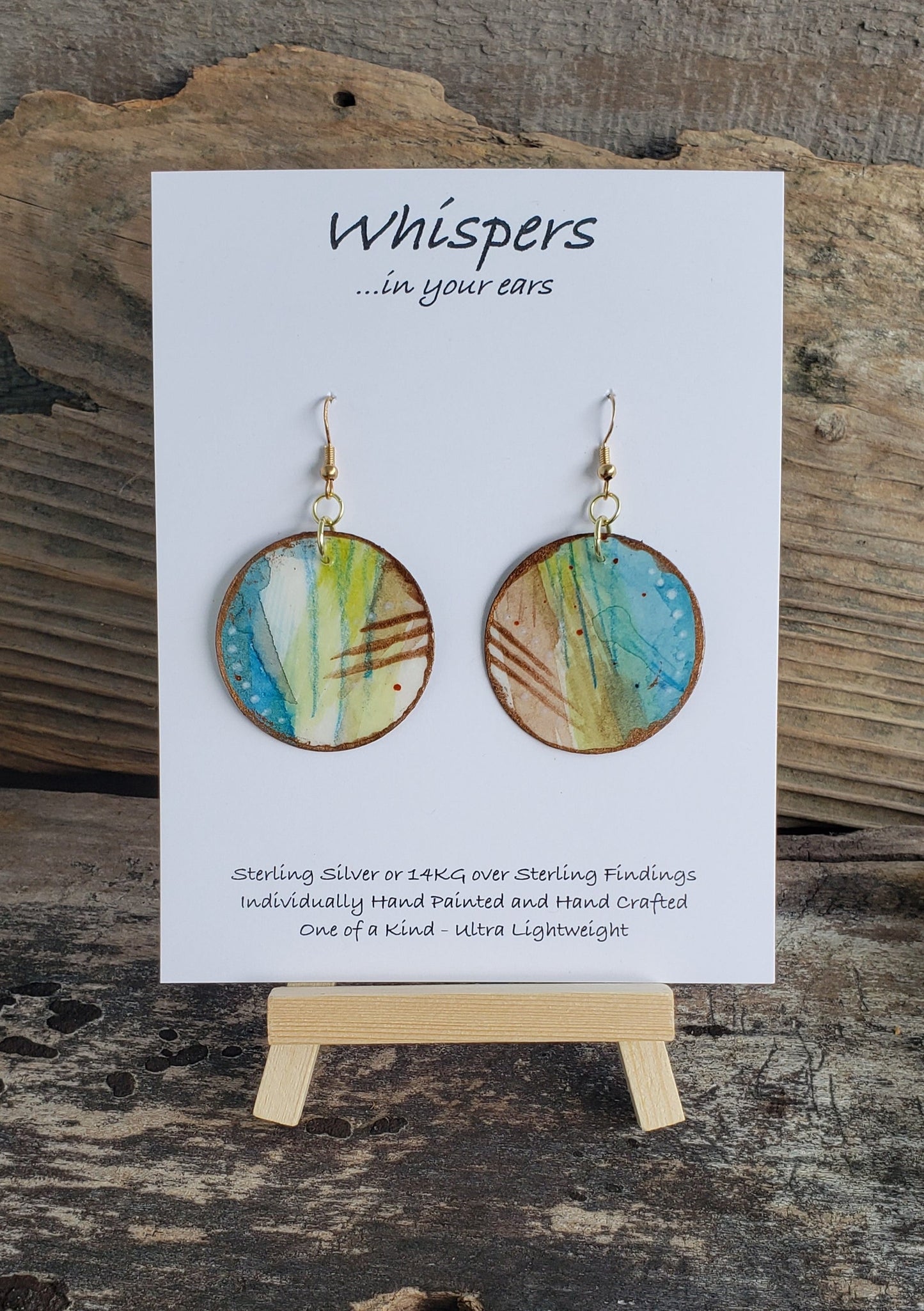 Hand painted watercolor ultra lightweight paper earrings. Blues lime greens brown scratch and white dot accents in pencil and acrylic. Gold edges.  Back painted with similar colors.  Circular in shape. 14kg over silver. Hangs  1 3/4" in Length