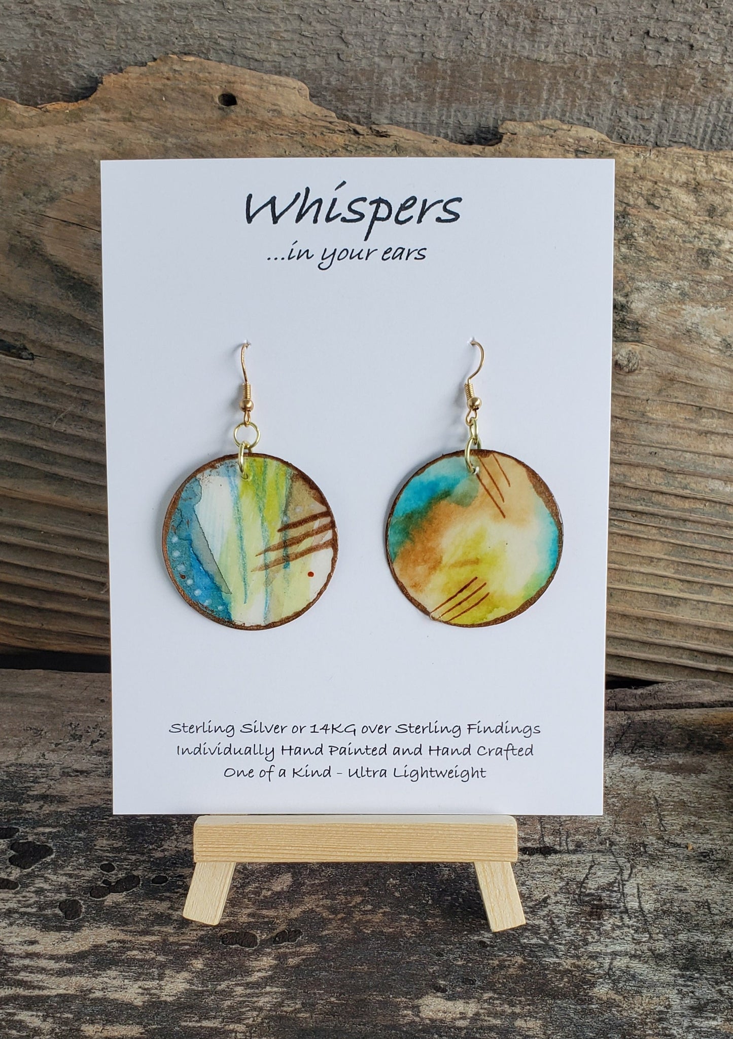 Hand painted watercolor ultra lightweight paper earrings. Blues lime greens brown scratch and white dot accents in pencil and acrylic. Gold edges.  Back painted with similar colors.  Circular in shape. 14kg over silver. Hangs  1 3/4" in Length