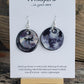 Hand painted hand crafted ultra lightweight paper earrings. Bluish grey black and white tie-dyed background. 3-D Dragonfly silhouette embellishment atop. Double Layer. Painted black edges. Back layer painted black and grey. Circular in shape sterling silver findings. Hangs 1 3/4" in Length