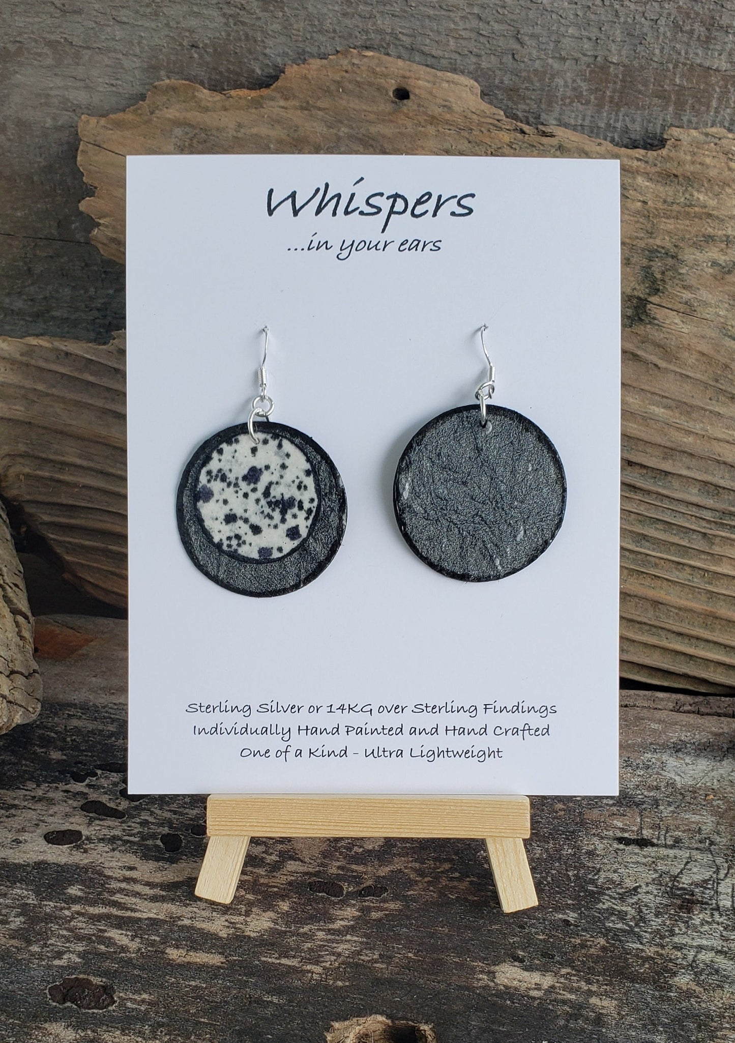 Hand painted ultra lightweight paper earrings. Mini cow print. Double Layer Iridescent Silver Textured Paper. Black painted edges. Back is silver. Circular in shape. Sterling silver findings. Hangs 1 3/4" in Length