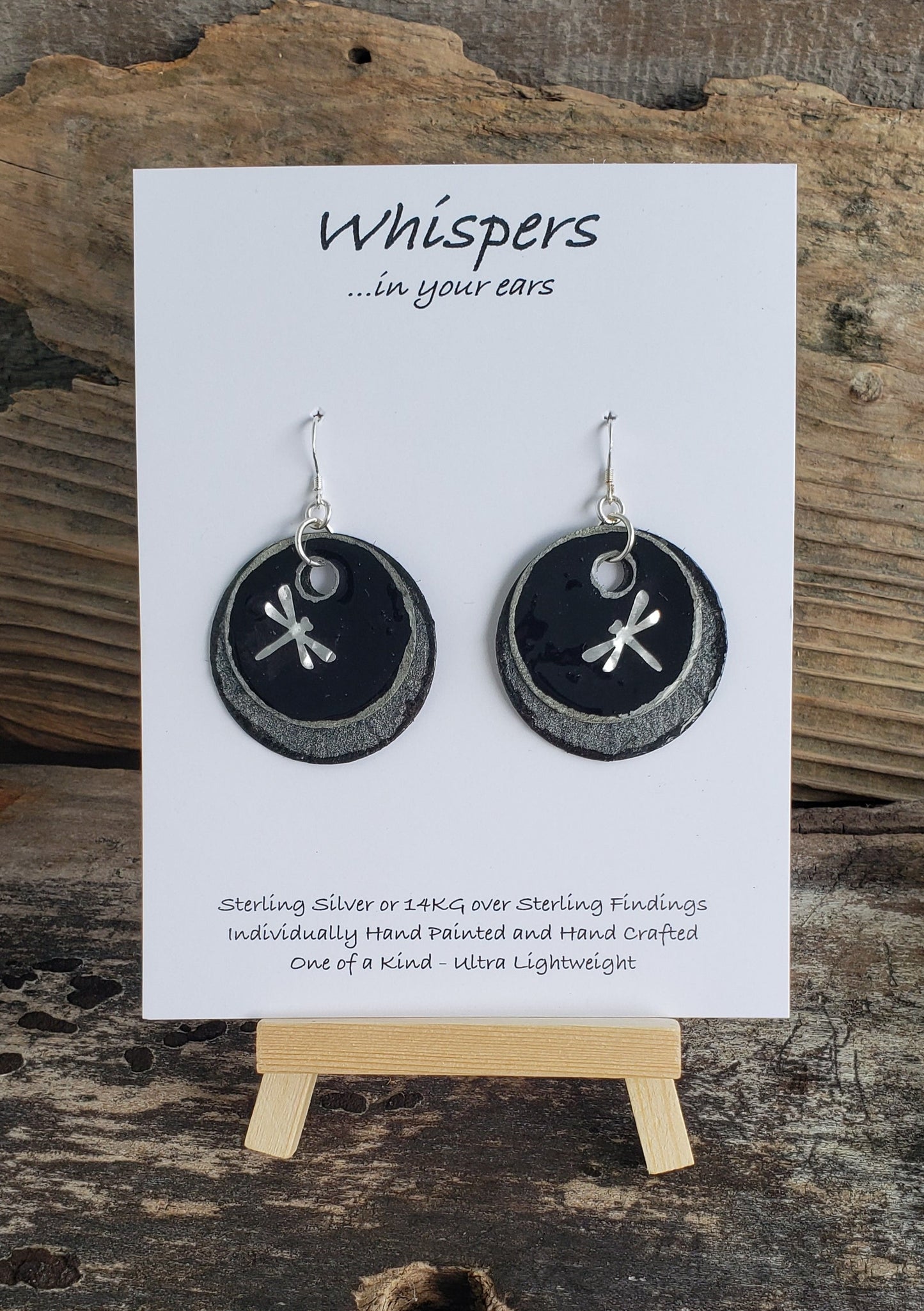 Hand crafted hand painted ultra lightweight paper earrings.  Glossy black with metal 3-D Dragonfly accent. Iridescent pewter textured double Layer Circular in shape. Sterling silver findings. Hangs 1 3/4" in Length